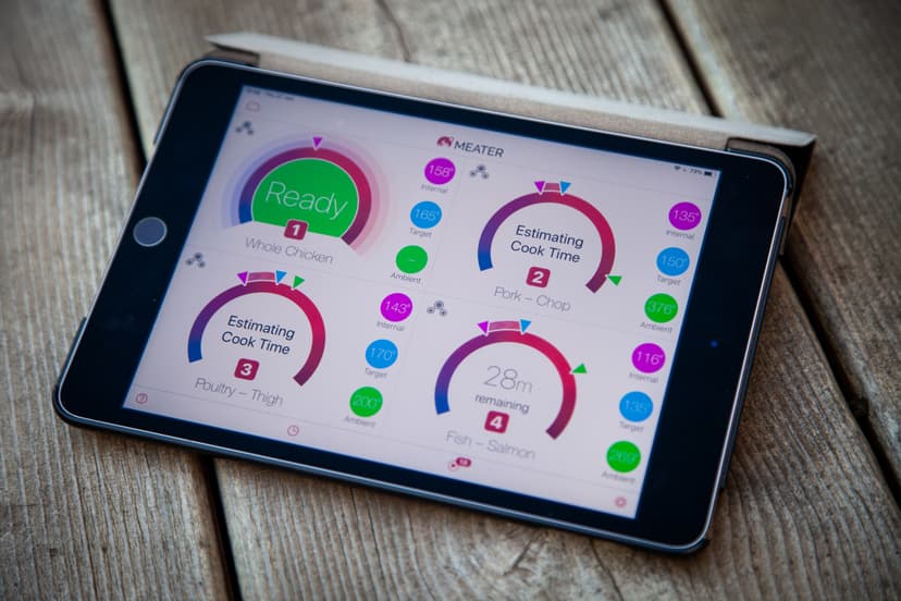 MEATER-app op tablet — vier probes tegelijk volgen MEATER-app op iPad toont vier gelijktijdige kookprocessen: hele kip, varkenshaas, kippendij en zalm met live kerntemperatuur