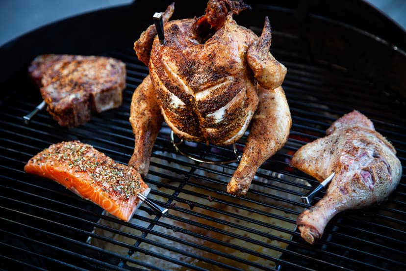 MEATER op de BBQ — kip, biefstuk, zalm en kippenpoot tegelijk Beer-can-chicken op de kogelbarbecue met MEATER probes in een biefstuk, zalmfilet en kippenpoot — vier stukken vlees tegelijk monitoren